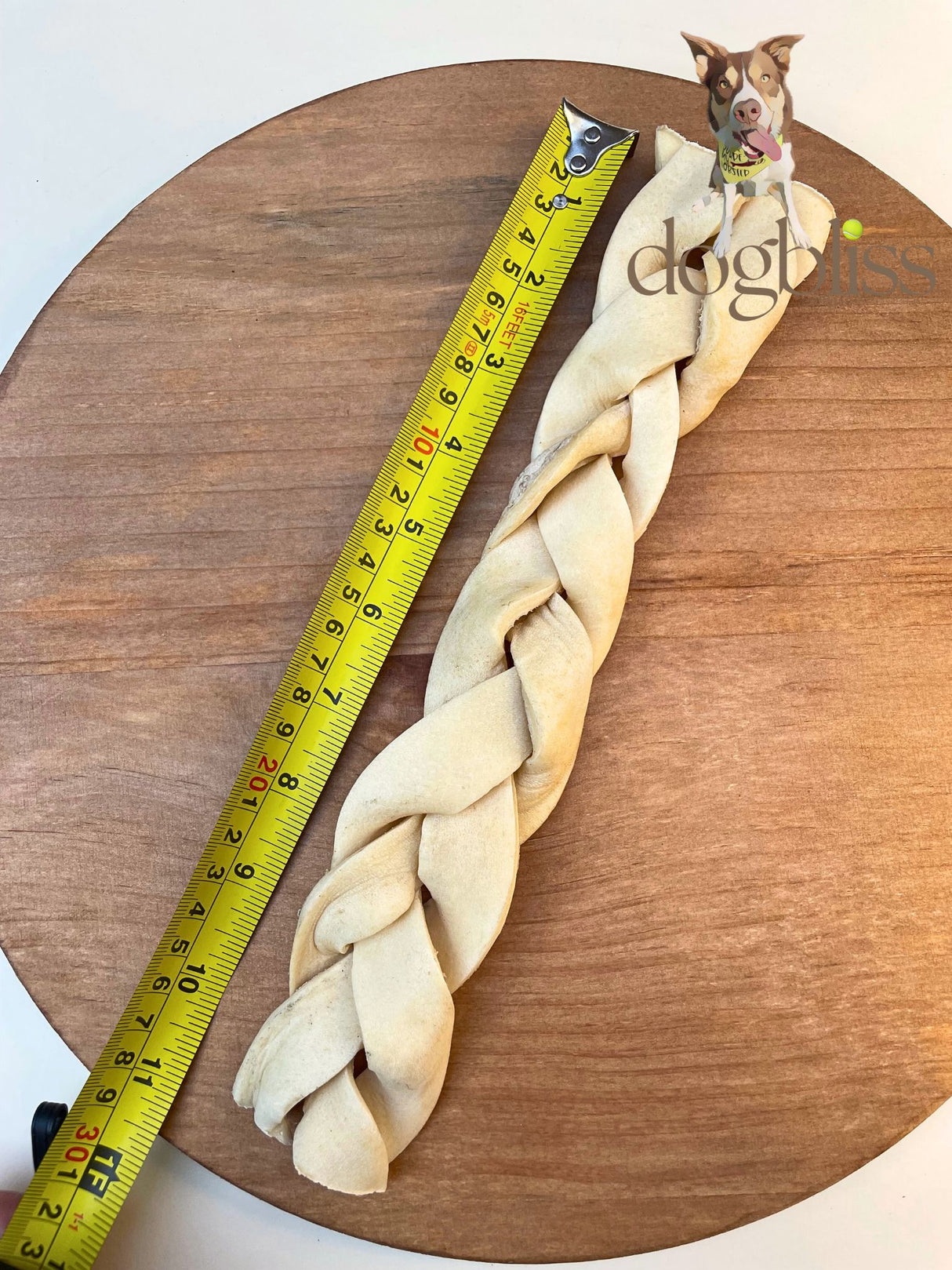 Long braided dog toy with a measuring tape for scale on a wooden surface, featuring the brand 'Doggylicious'.