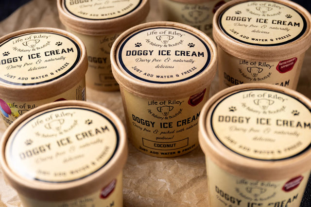 Multiple containers of 'Doggy Ice Cream' with visible branding on a textured surface.