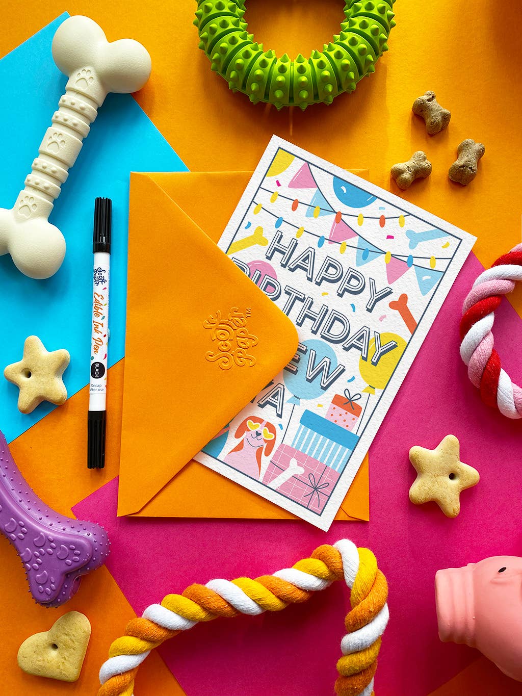 Colorful birthday card with envelope and dog toys on a multicolored background