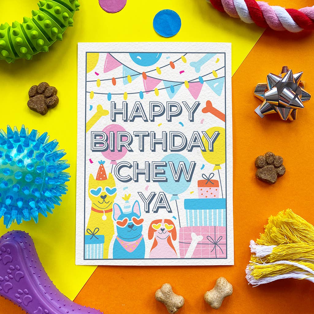 A square birthday card for a pet, reading 'HAPPY BIRTHDAY CHEW YA', surrounded by colorful dog toys, treats, and a gift box on a bright yellow and orange background.