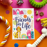 Colorful card with 'Friends for Life' text surrounded by pet toys on a pink and orange background