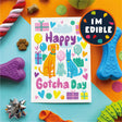 Colorful 'Happy Gotcha Day' card with dog illustrations surrounded by dog toys on a multicolored background.