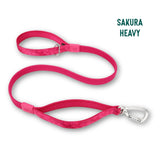 A bright pink dog leash with a silver carabiner clip and metal buckle, shown on a white background with the text 'SAKURA HEAVY' in the top right corner.