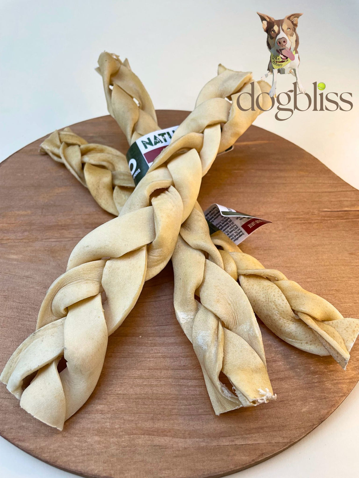 Braided dog chew toy on a wooden board with 'dogbliss' branding.
